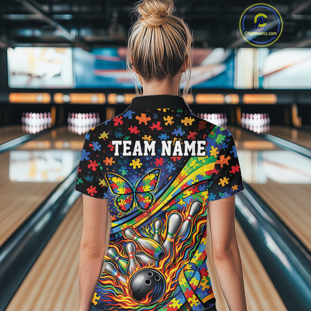 Back view of a female bowler wearing a colorful quarter-zip shirt, autism awareness design with ribbon, butterfly, and bowling-themed graphics.
