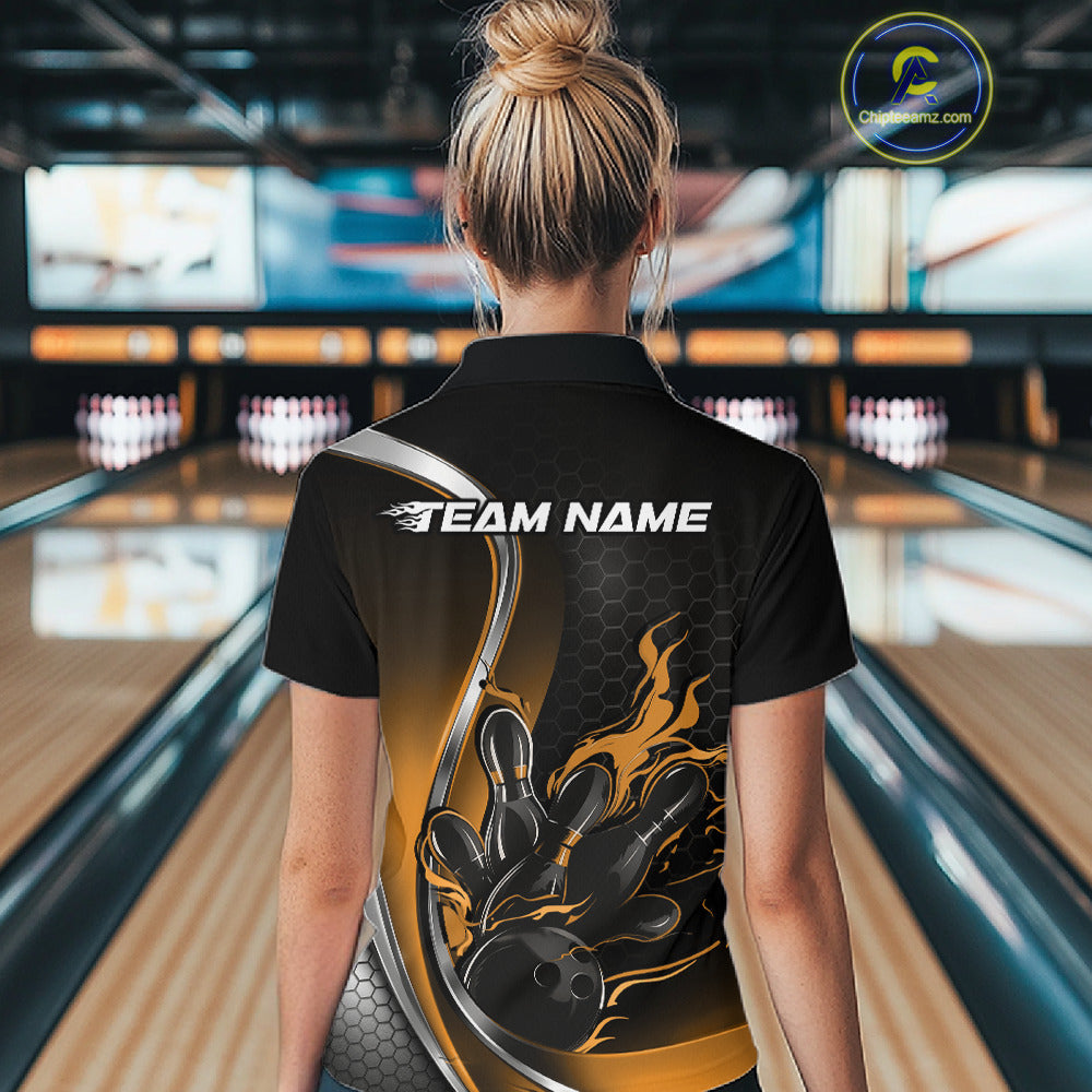Female model back view at bowling lane wearing a black and yellow polo shirt with flaming bowling ball hitting pins in bold athletic motion artwork.