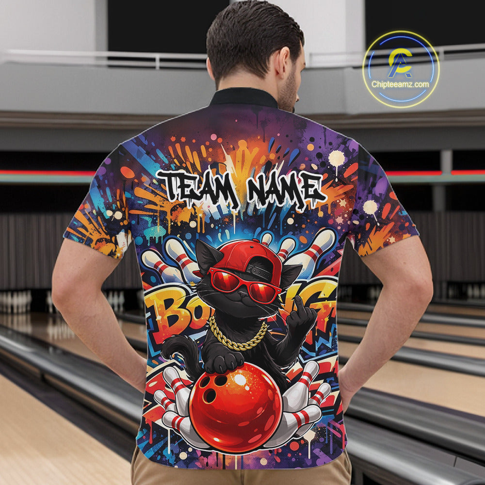 Front view of a male model in a bowling alley wearing a vibrant bowling quarter-zip shirt featuring a black cat in sunglasses leaning on a bowling ball.