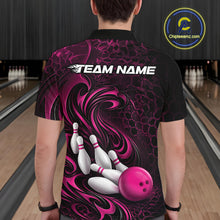 Load image into Gallery viewer, Back view of a male model wearing a black and pink bowling polo shirt in a bowling alley featuring a tribal flame bowling ball and pins graphic