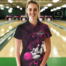 Load image into Gallery viewer, Female model wearing a black and pink bowling polo shirt in a bowling alley featuring a tribal flame bowling ball and pins graphic