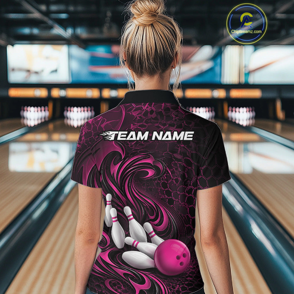 Back view of a female model wearing a black and pink bowling polo shirt in a bowling alley featuring a tribal flame bowling ball and pins graphic