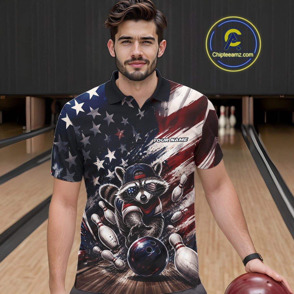 Front view of a male model at a bowling lane wearing a bowling polo shirt with a raccoon in patriotic sunglasses rolling a bowling ball through scattered pins against a distressed American flag backdrop.
