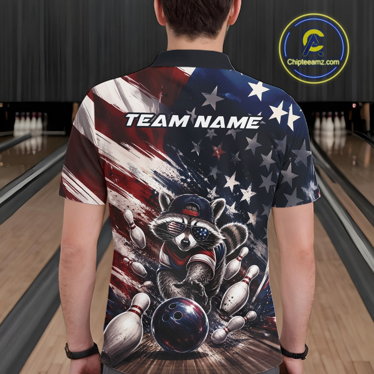 Back view of a male model at a bowling lane wearing a bowling polo shirt with artwork of a raccoon in patriotic sunglasses rolling a bowling ball through scattered pins and a distressed American flag backdrop.