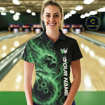 Female model wearing a black bowling polo shirt in a bowling alley featuring a skull clutching a bowling ball with swirling green energy flames