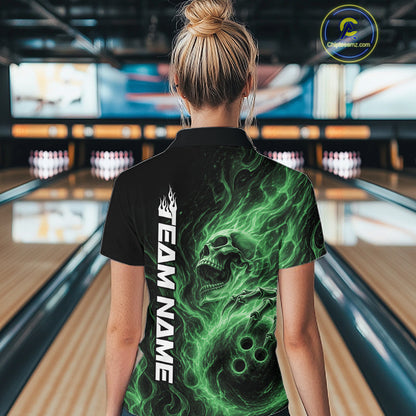 Back view of a female model wearing a black bowling polo shirt in a bowling alley featuring a skull clutching a bowling ball surrounded by swirling green energy flames