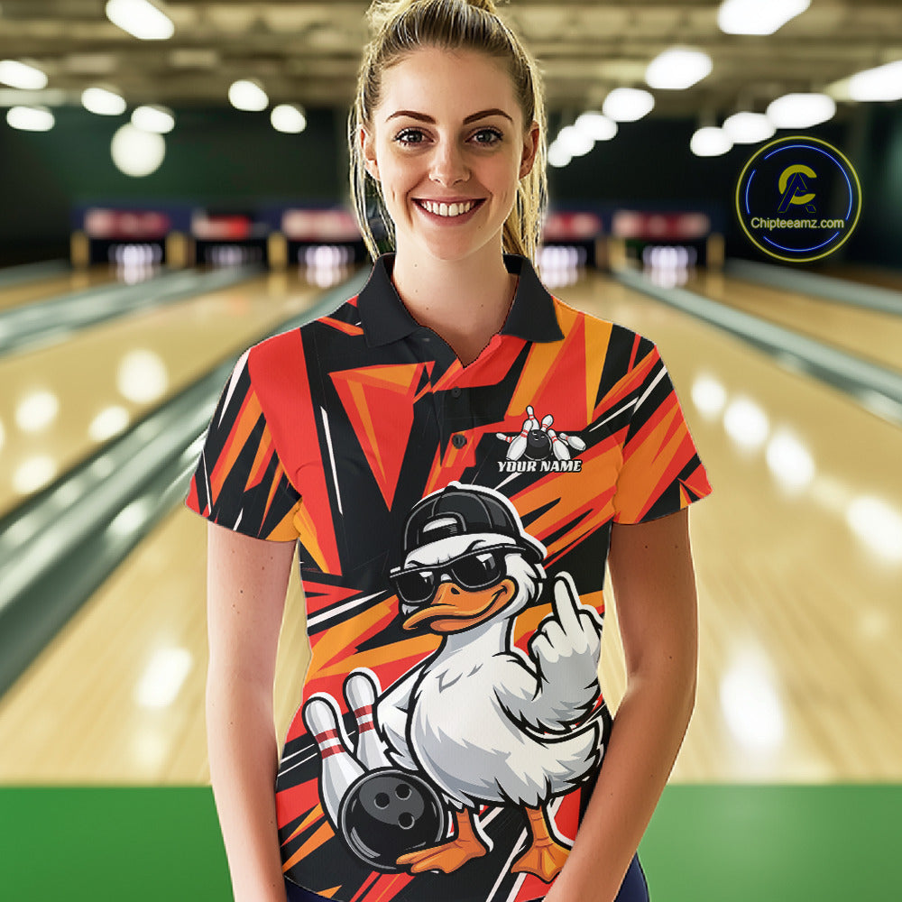 Female model wearing a black and orange bowling polo featuring a duck in sunglasses and cap with bowling lane-inspired artwork.