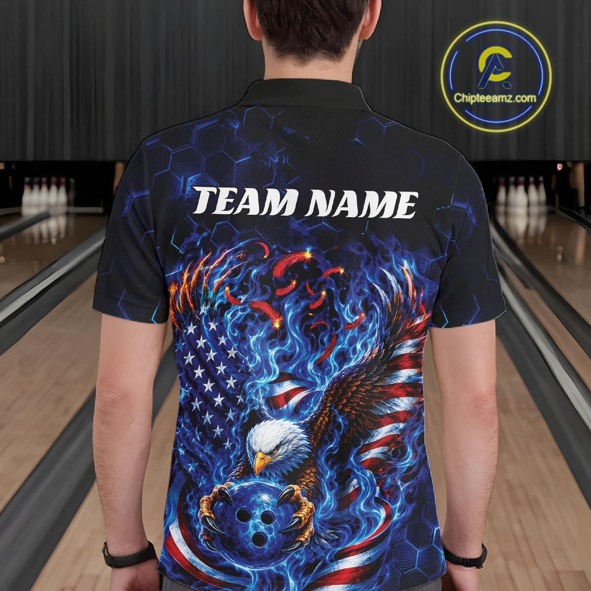 Back view of a male model in a bowling lane wearing a polo shirt with flaming bald eagle, blue bowling ball, American flag, and blue flames.