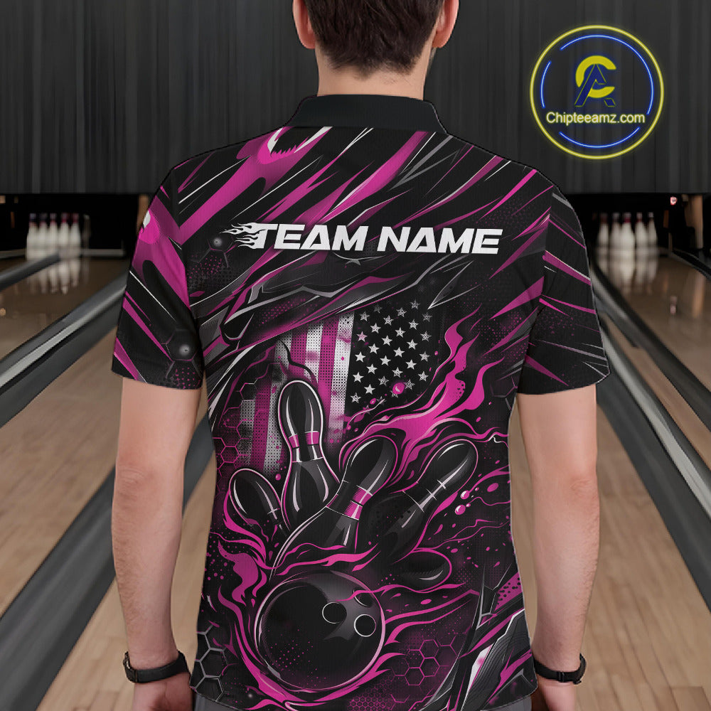 Back view of a male model in a bowling alley wearing a black and pink polo shirt featuring a fiery bowling strike design with patriotic accents.