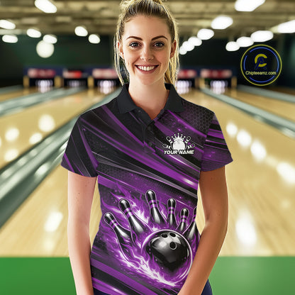 Female model at a bowling lane wearing a black and purple bowling polo shirt with flaming bowling artwork and modern stripe accents.