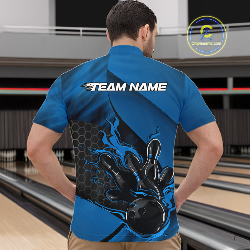 Front view of a male model in a bowling center wearing a black and blue quarter-zip shirt featuring a flaming bowling ball knocking down pins.
