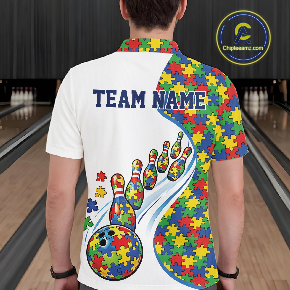 Male model at a bowling lane, back view of white polo shirt showcasing colorful autism bowling strike illustration with puzzle graphics