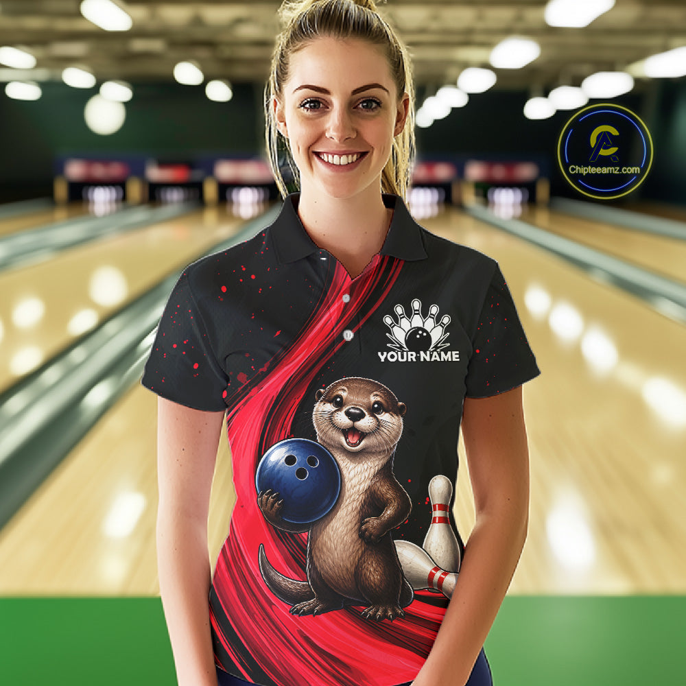 A woman stands in a bowling alley wearing a black short-sleeve polo shirt with a red diagonal graphic, an otter holding a blue bowling ball, bowling pins, and a white 'YOUR NAME' placeholder on the chest. A circular 'ChipTEEamz.