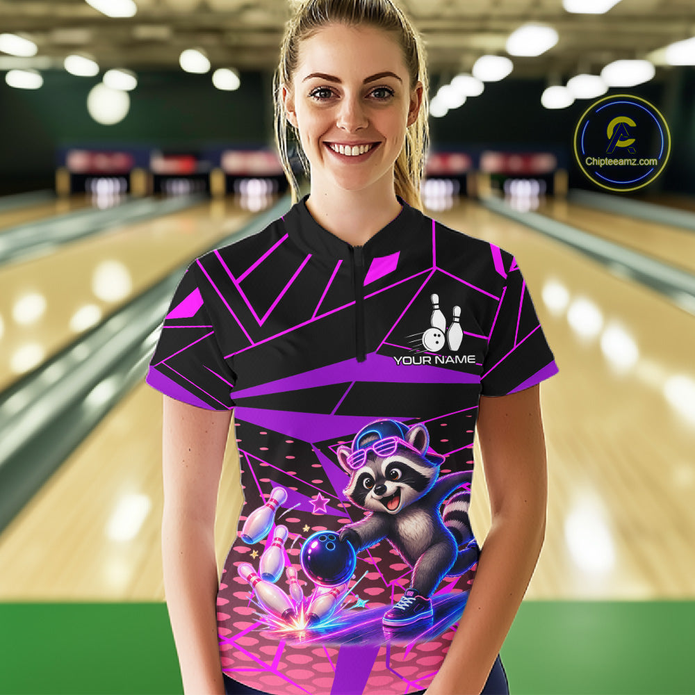 Person wearing a colorful bowling shirt with a raccoon design in a bowling alley.