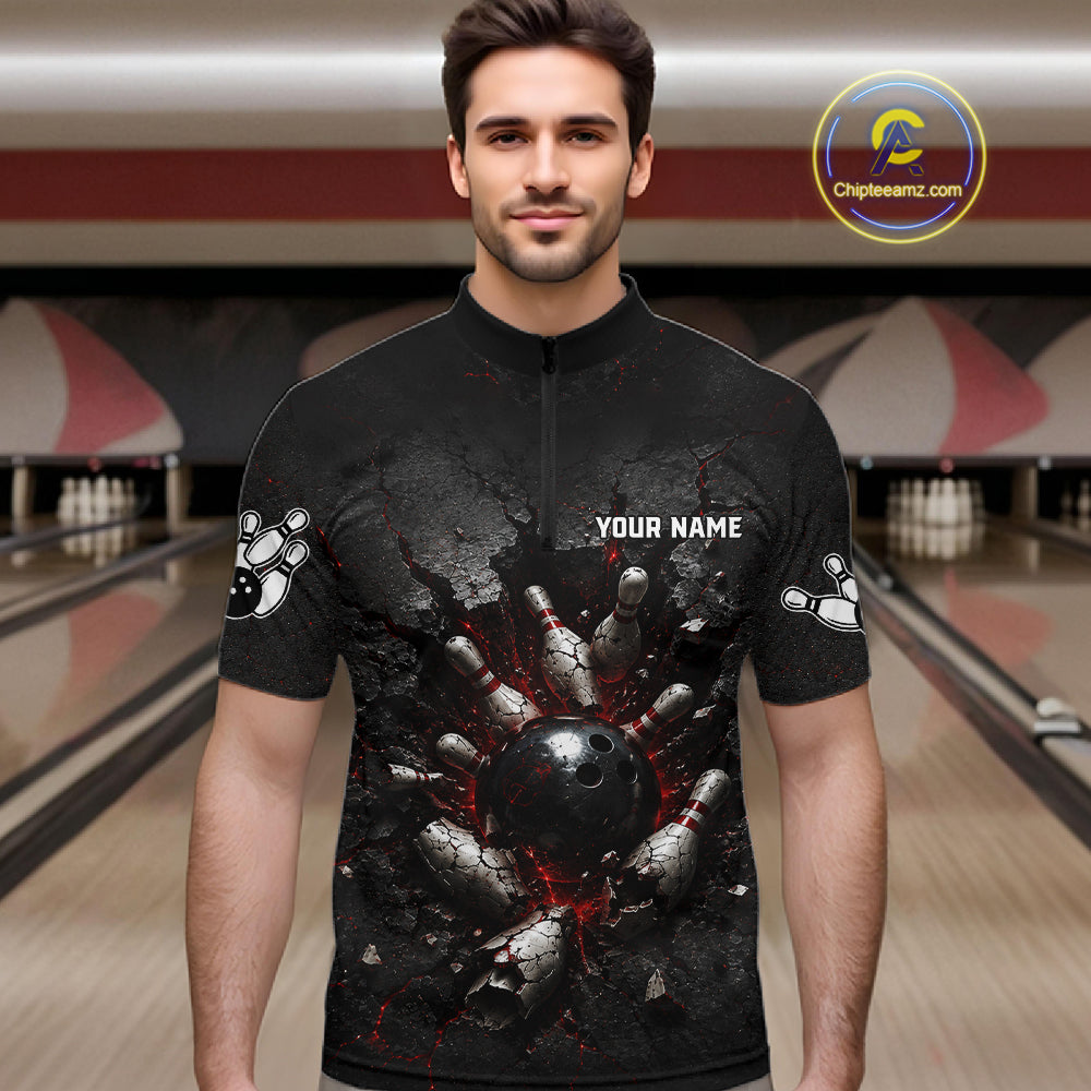 Man wearing a black bowling shirt with a graphic design in a bowling alley.