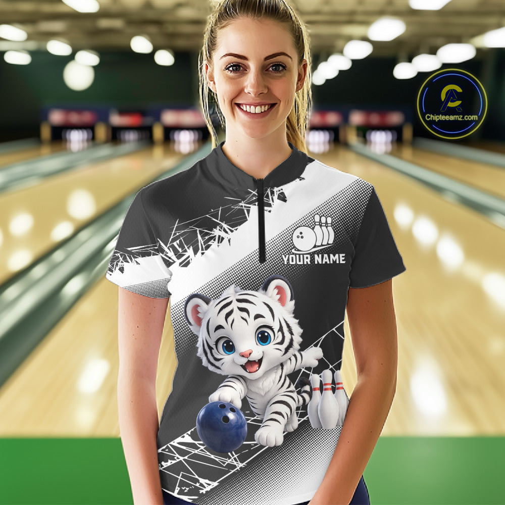 Woman wearing a bowling shirt with a tiger design in a bowling alley.