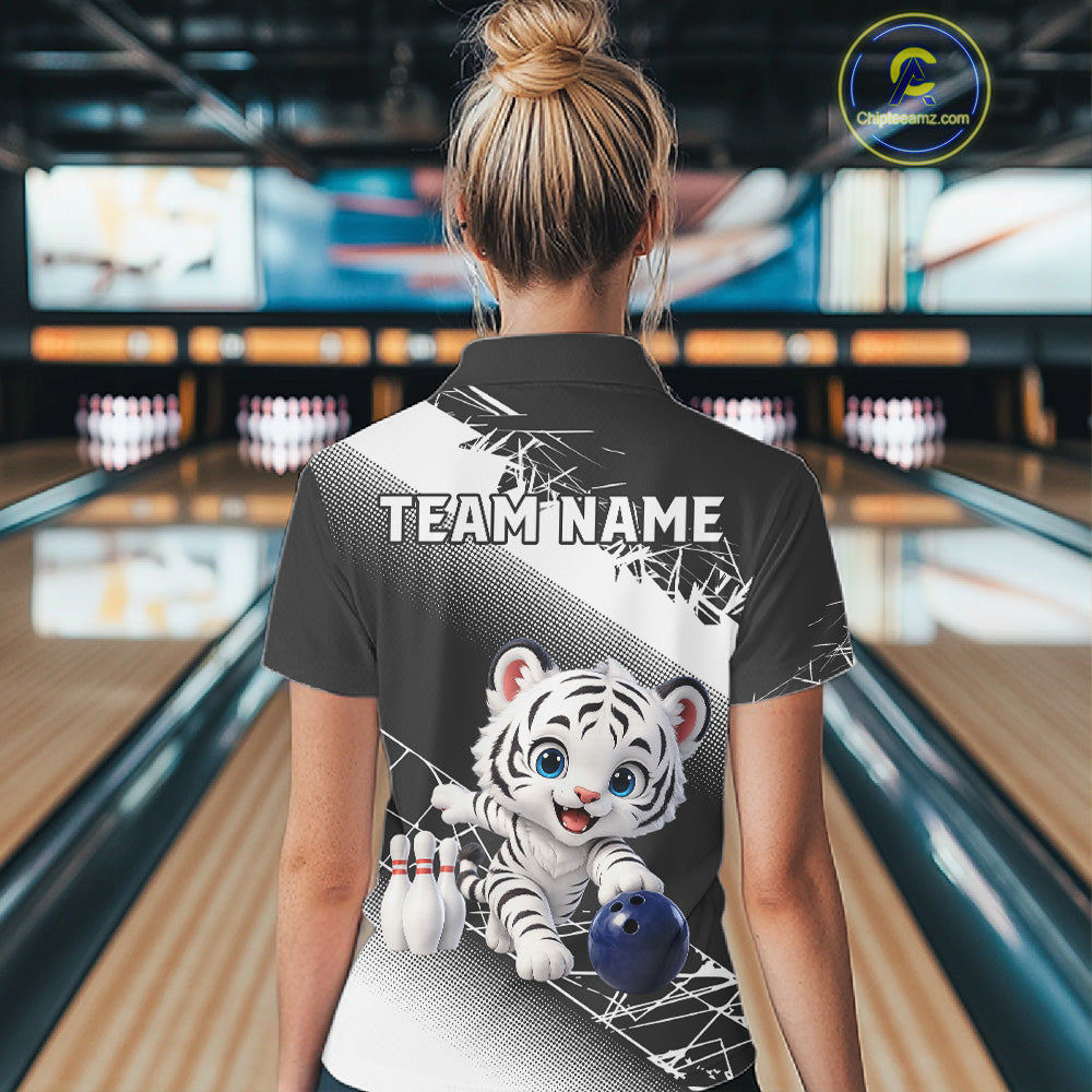 Person wearing a bowling shirt with a tiger design and 'TEAM NAME' text in a bowling alley.