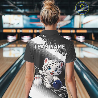 Person wearing a bowling shirt with a tiger design and 'TEAM NAME' text in a bowling alley.