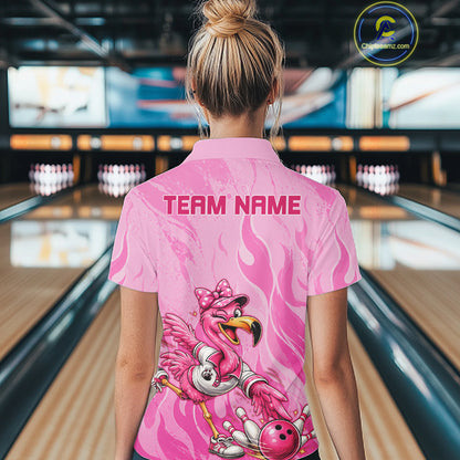 A woman viewed from behind wearing a pink short-sleeve bowling shirt with a flamingo graphic and the text 'TEAM NAME' on the back, standing in a bowling alley.