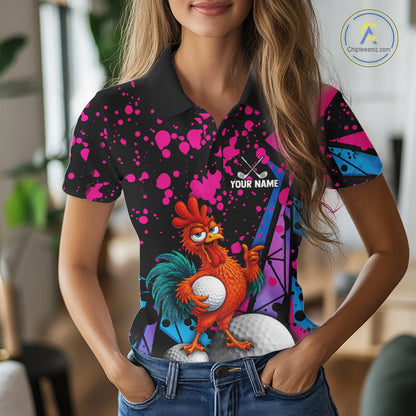 A woman wearing a short-sleeve polo shirt with a colorful graphic print featuring a cartoon rooster, golf balls, and pink paint splatters on a black background. The shirt has a custom placeholder design with the text 'YOUR NAME' and a golf club icon.