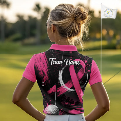 A woman on a golf course seen from behind, wearing a short-sleeve collared athletic top with bright pink sleeves and collar, and a black back panel featuring a pink awareness ribbon, brushstroke pattern, and the text 'Team Name'.