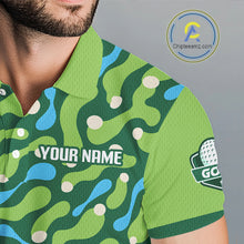 Load image into Gallery viewer, Green camouflage-patterned shirt with branding on a gray background