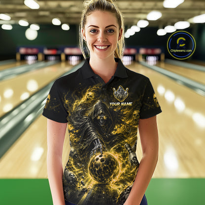 Woman wearing a black and yellow shirt with a design of a skeleton holding a bowling ball in a bowling alley.