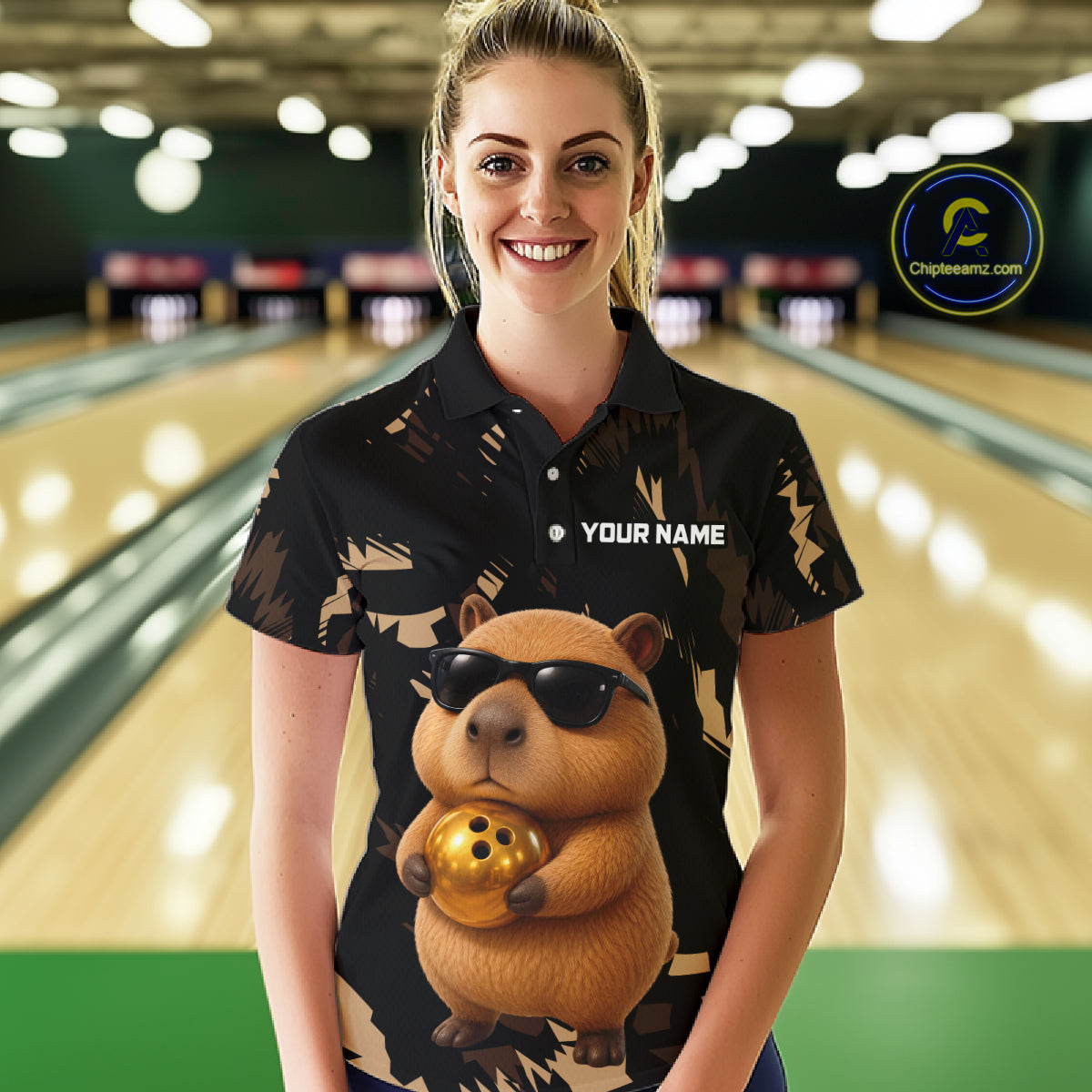 Woman wearing a black bowling shirt with a capybara design in a bowling alley.