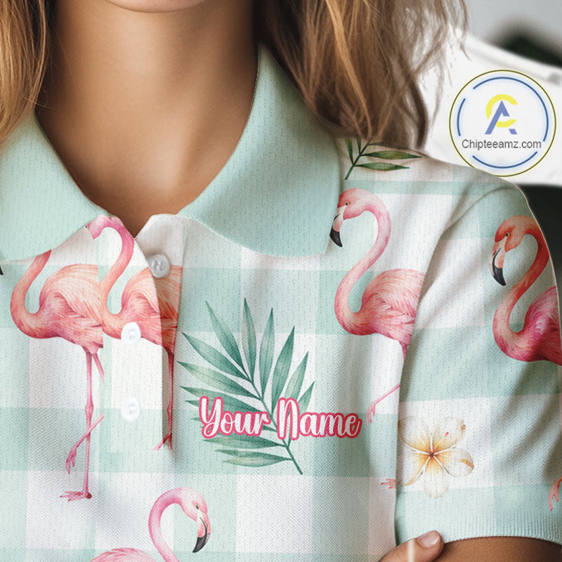 A close-up of a person wearing a light mint green and white plaid polo shirt with pink flamingo prints, green palm leaves, and a customizable name patch on the chest. A brand watermark for 'Chipteamz.