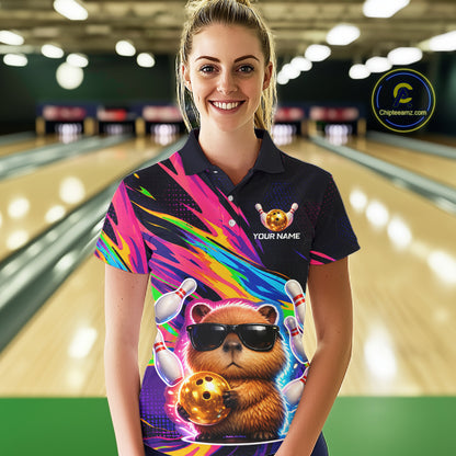 Woman wearing a colorful bowling shirt with a bear design in a bowling alley.