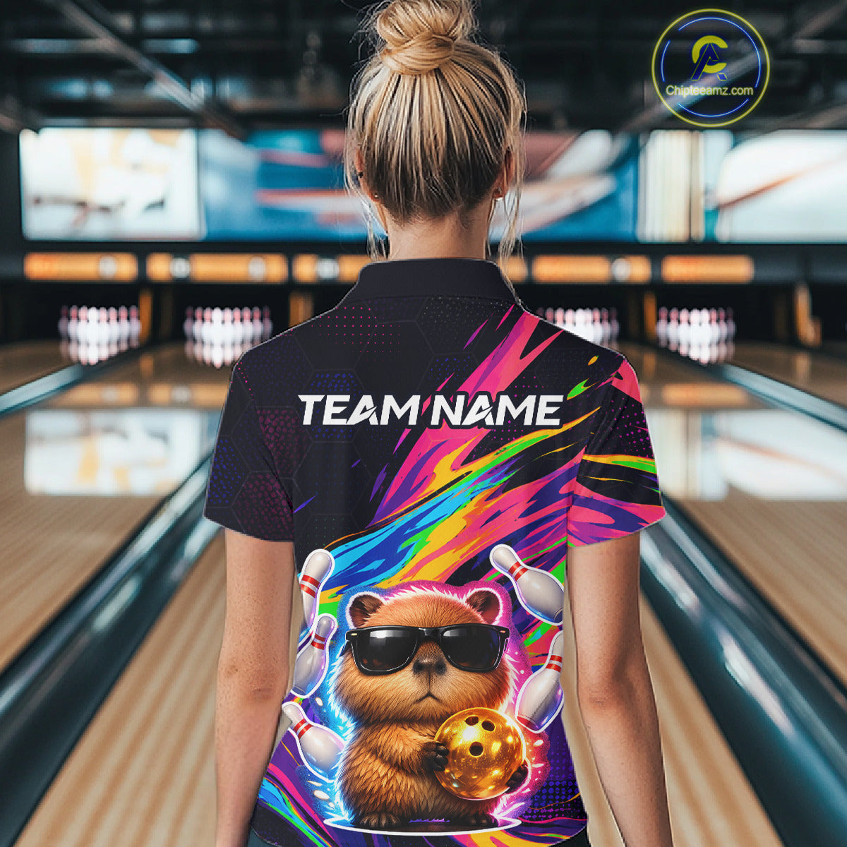 Person wearing a colorful bowling shirt with a bear design in a bowling alley.