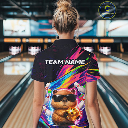 Person wearing a colorful bowling shirt with a bear design in a bowling alley.
