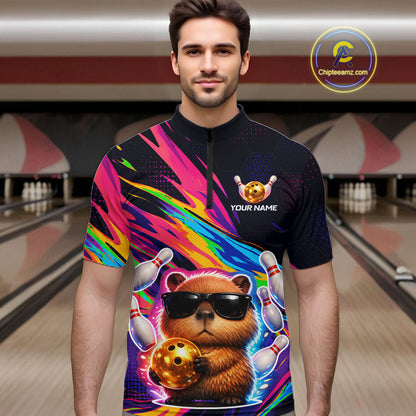 Man wearing a colorful bowling shirt with a capybara design in a bowling alley.