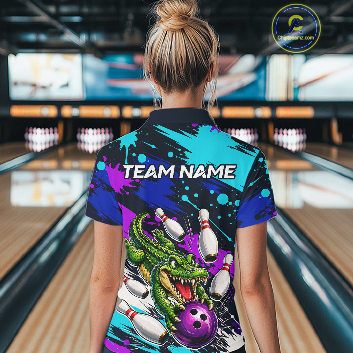 Person wearing a colorful bowling shirt with a dragon design in a bowling alley.