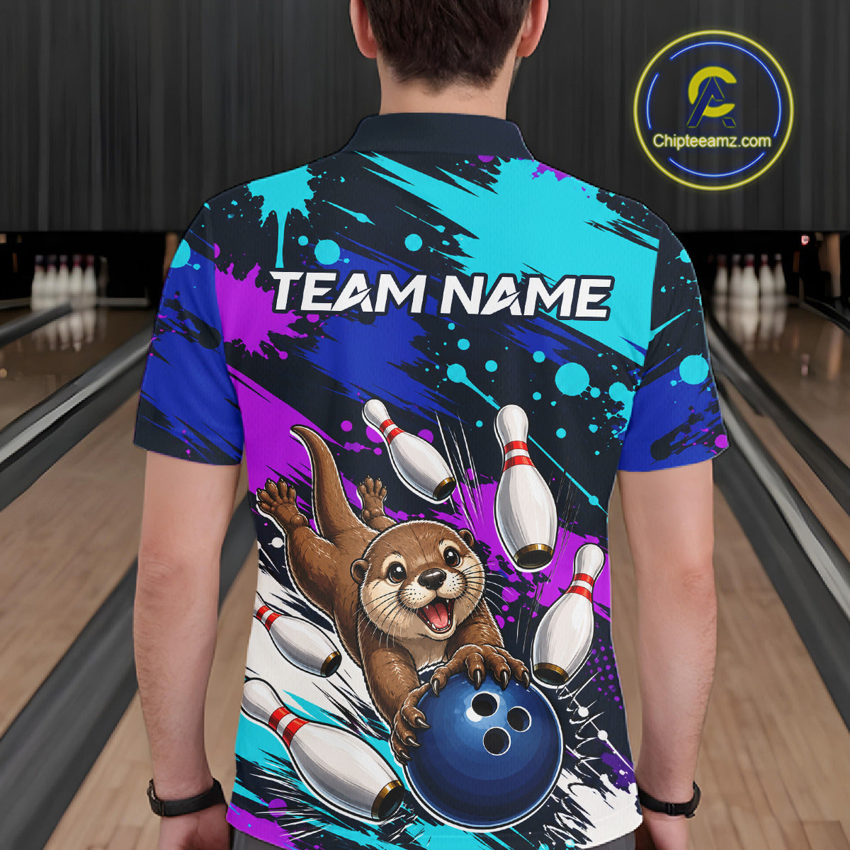 Person wearing a colorful bowling-themed shirt with an otter character in a bowling alley.