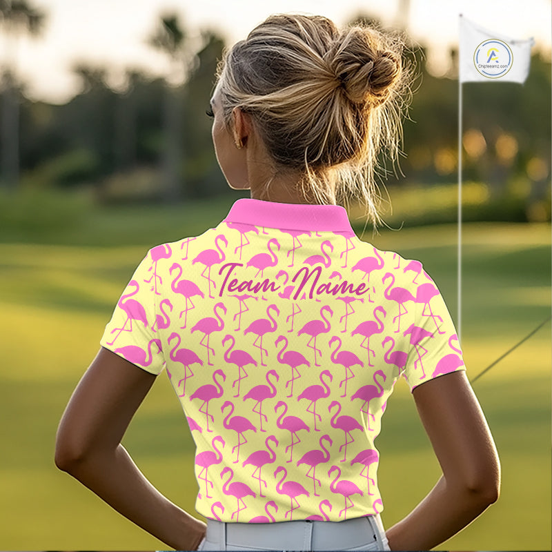 Woman wearing a yellow polo shirt with pink flamingo pattern and 'Team Name' text on the back, standing on a golf course.