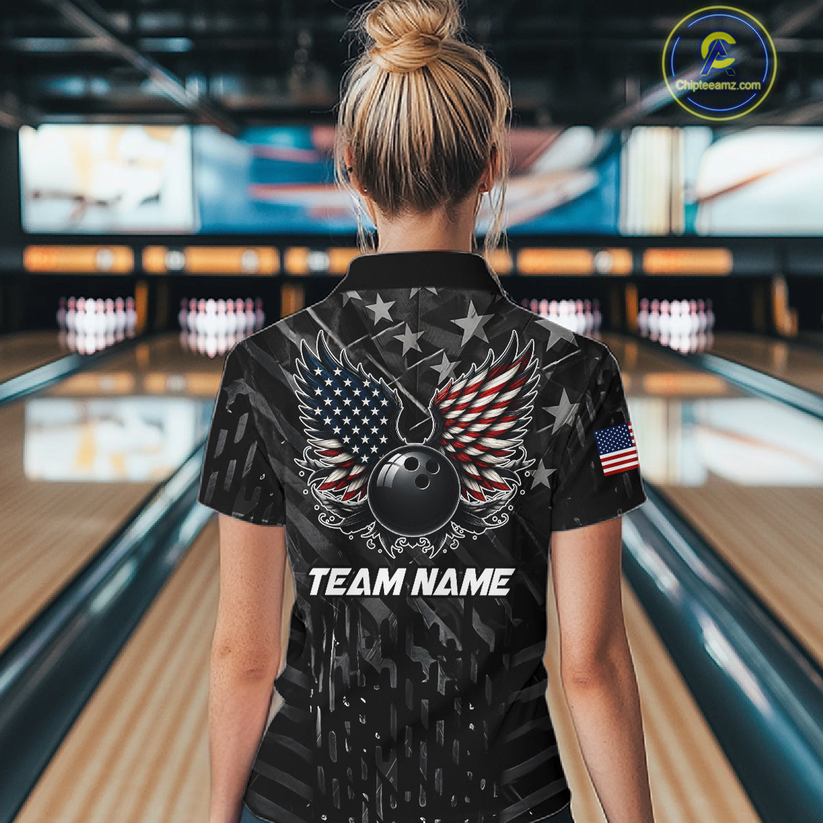 Back view of woman wearing a black American flag wings bowling polo shirt inside a bowling alley.