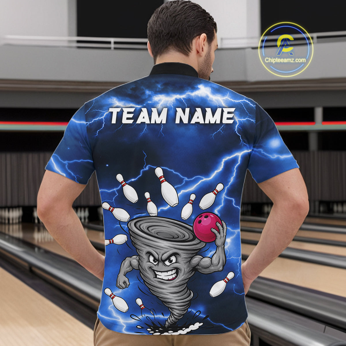 Back view of man wearing a blue thunder lightning tornado bowling quarter zip shirt in a bowling alley.