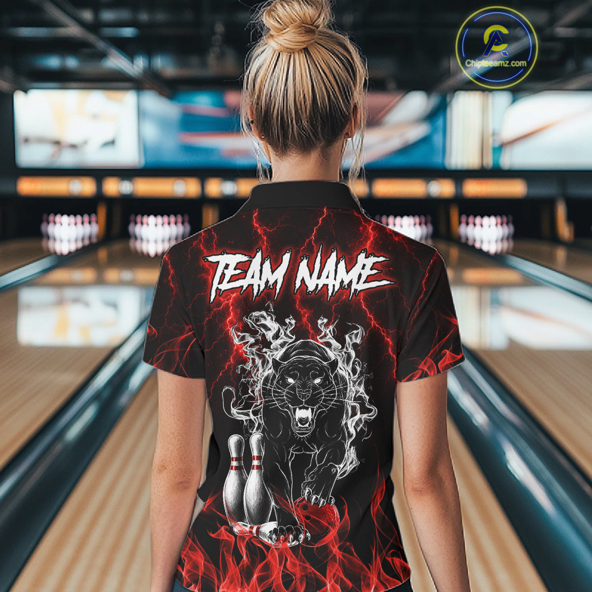 Back view of woman wearing a red flaming panther bowling polo shirt inside a bowling alley.