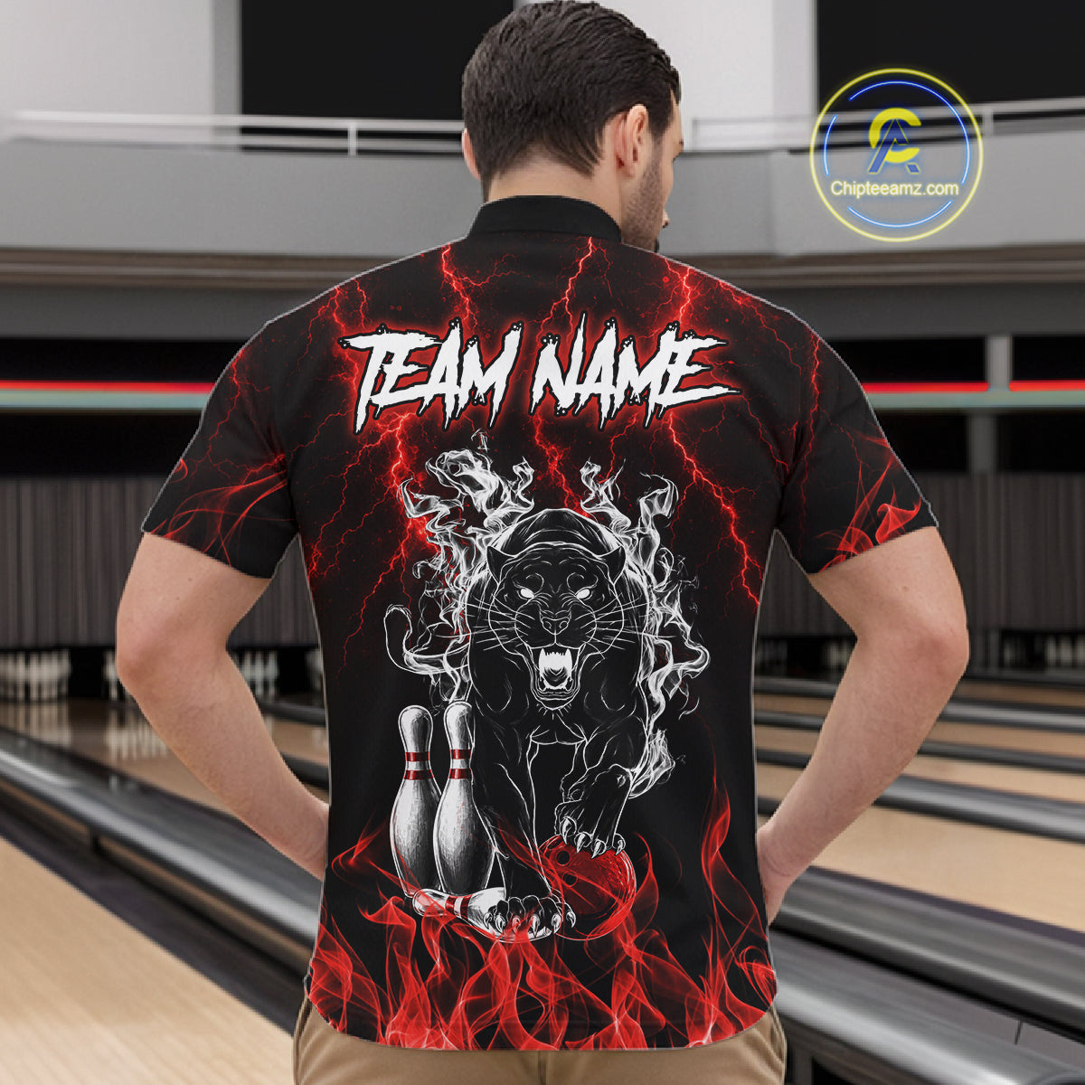 Back view of man wearing a red flaming panther bowling quarter zip shirt in a bowling alley.