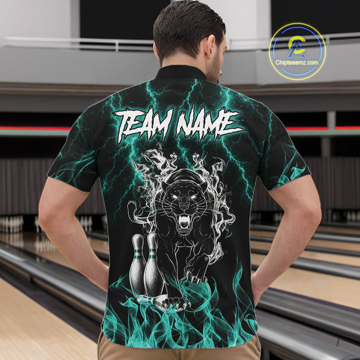 Back view of man wearing a turquoise flaming panther bowling quarter zip shirt in a bowling alley.