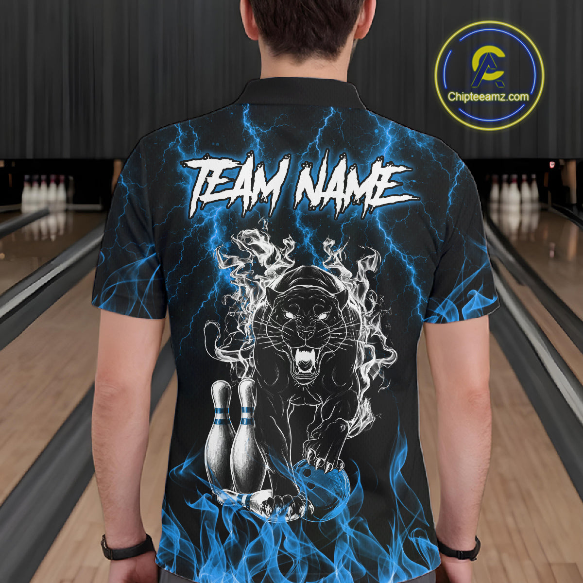 Back view of man wearing a blue flaming panther bowling polo shirt inside a bowling alley.
