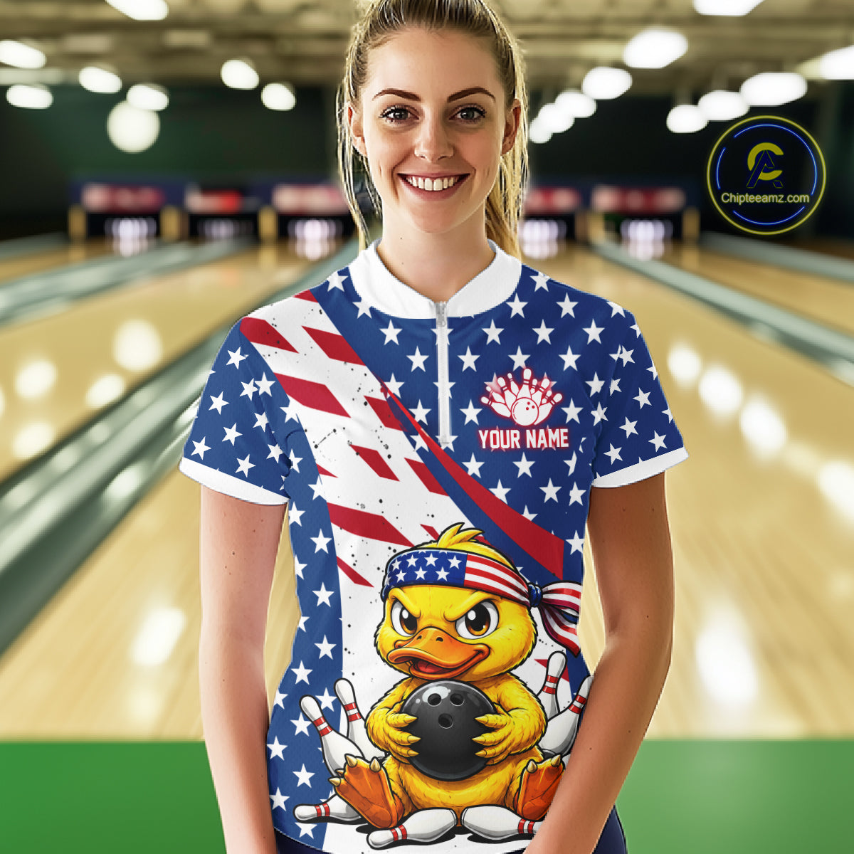 Person wearing a bowling shirt with a duck holding a bowling ball design and American flag, in a bowling alley.