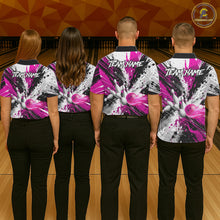 Load image into Gallery viewer, Back view of bowling team wearing matching pink splatter bowling shirts in a bowling alley.