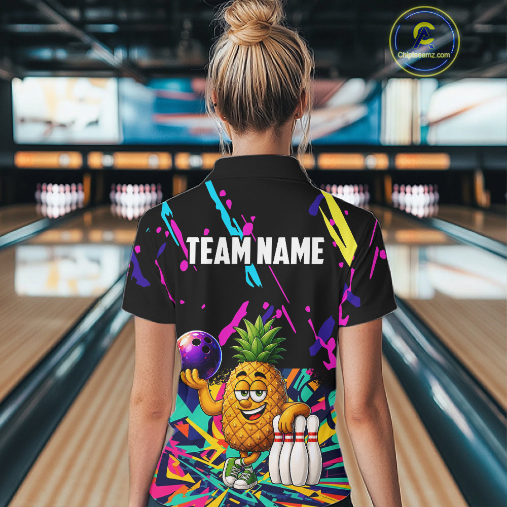 Back view of woman wearing a colorful pineapple bowling polo shirt inside a bowling alley.