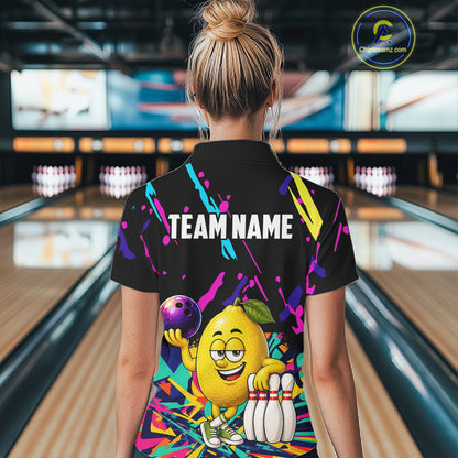 Back view of woman wearing a colorful lemon bowling polo shirt inside a bowling alley.