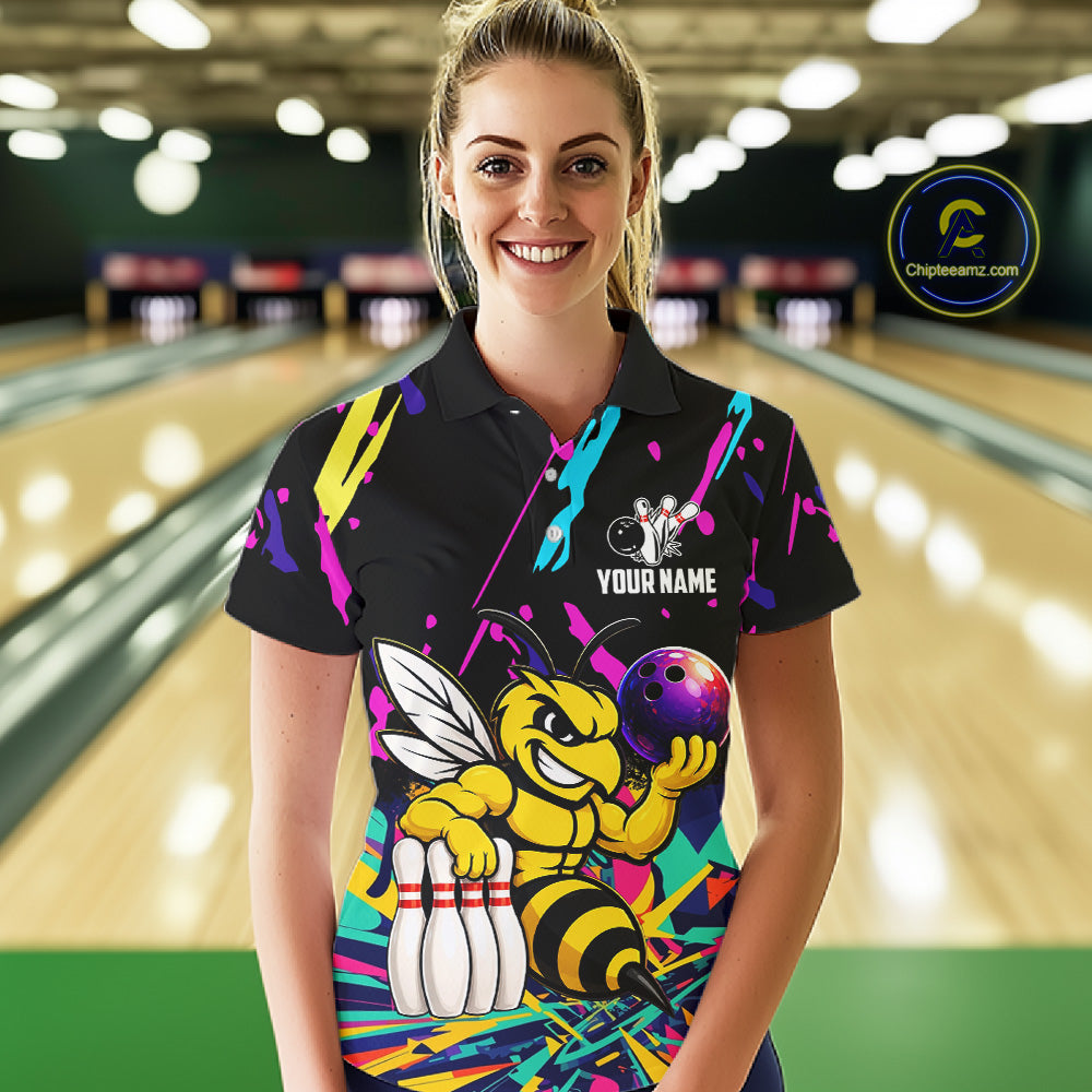 Woman wearing a colorful bowling-themed shirt with a bee graphic in a bowling alley.