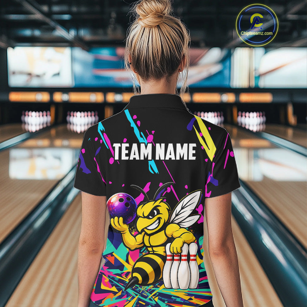 Person wearing a colorful bowling-themed shirt with a bee design in a bowling alley.