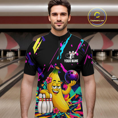 Man wearing a colorful bowling shirt with a cartoon banana character in a bowling alley.