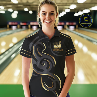 Woman wearing a black and gold crown bowling ball polo shirt at a bowling alley front view.
